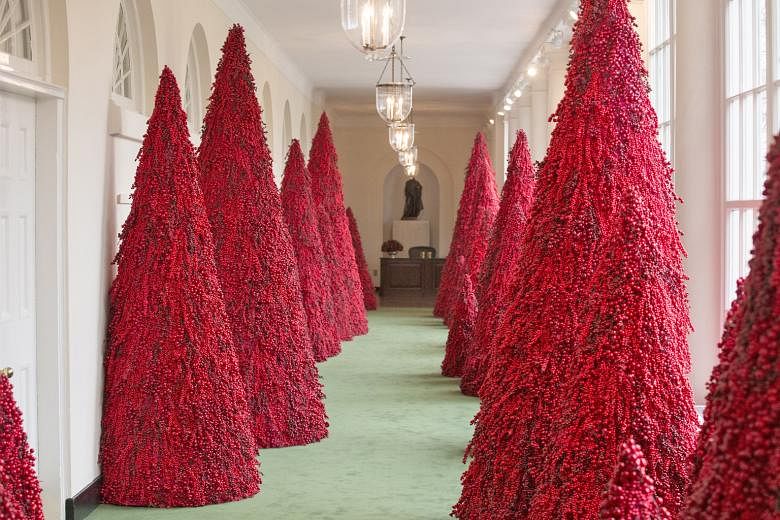Red Christmas trees along the East Colonnade of the White House in Washington. The theme of this year's Christmas decorations is "American Treasures", says a statement from Mrs Melania Trump's office. Critics, however, have described it as the "hallw