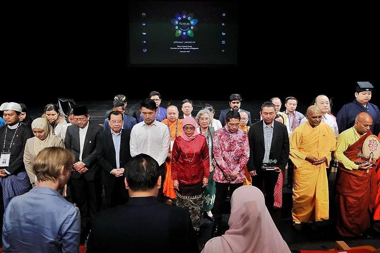 President Halimah Yacob (centre), flanked by Senior Minister of State for Defence and Foreign Affairs Maliki Osman on her left and Senior Parliamentary Secretary for Culture, Community and Youth and Transport Baey Yam Keng to her right, observing one