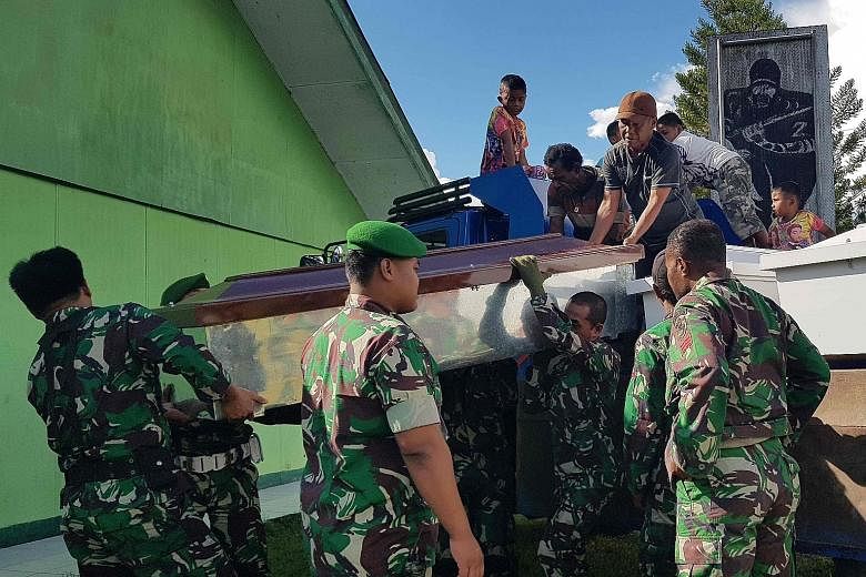 Indonesian soldiers preparing coffins yesterday for at least 24 construction workers, believed to have been killed by separatist rebels in restive Papua province.