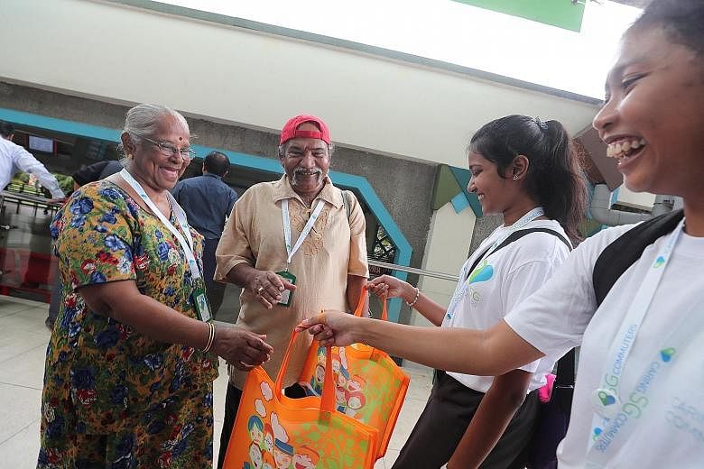 Madam Veerama Suppiah, 77, and her husband Paraman Nayar, 76, receiving goodie bags from Pioneer Junior College students Preshika Das and Dian Haziqah, both 17. Care Ride @ South West wants to "provide opportunities for younger commuters to better un