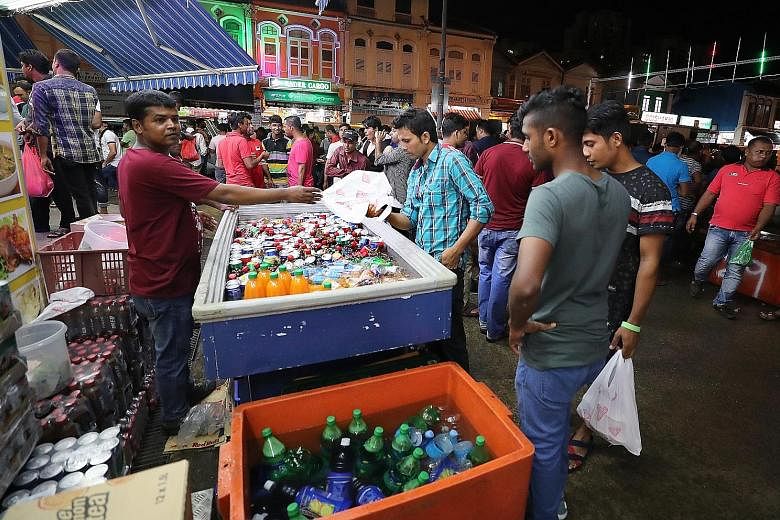 A seller hawking soft drinks along Desker Road. Some shopkeepers interviewed by ST reported dips in business as the crowd of migrant workers in Little India shrinks following the post-riot measures.