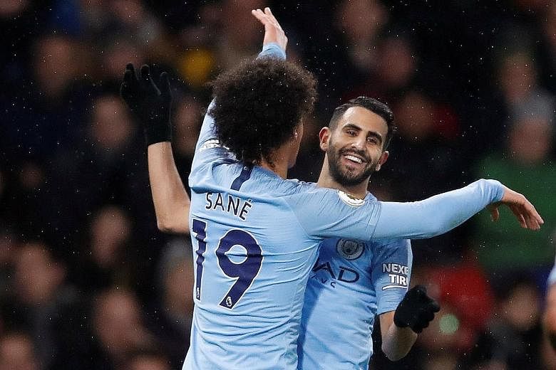 Leroy Sane celebrating with Riyad Mahrez after scoring City's first goal in the 2-1 away win over Watford on Tuesday. The team took their foot off the pedal when leading 2-0 and boss Pep Guardiola will not want a recurrence.