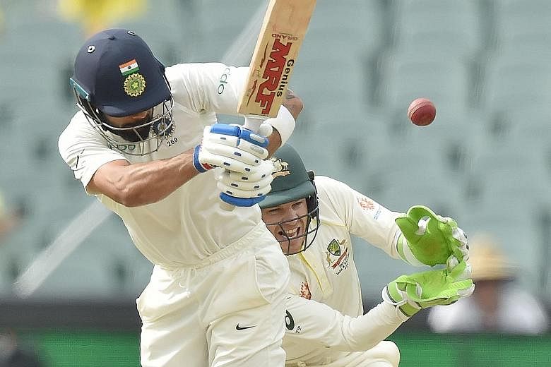 India captain Virat Kohli hitting a ball past Australia captain and wicket-keeper Tim Paine yesterday in the first cricket Test at the Adelaide Oval. The tourists are in control with a 166-run lead after three days and the hosts need to peg them back