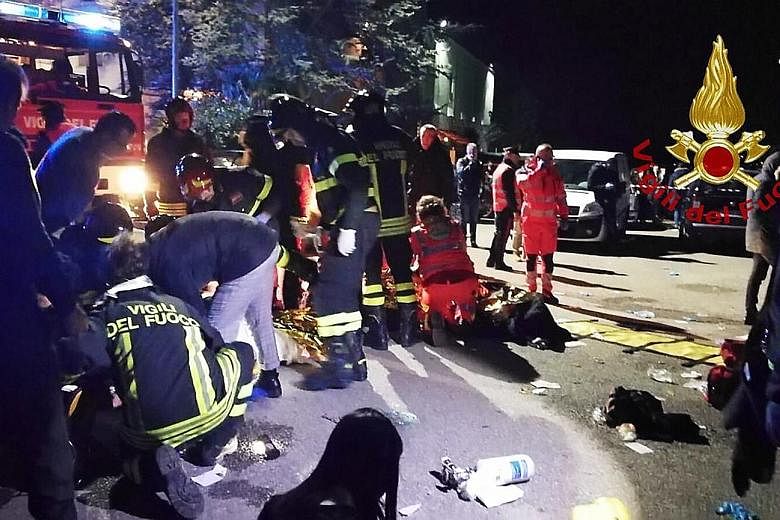 Emergency personnel treating victims after a stampede at a nightclub in the town of Corinaldo, central Italy, in the early hours of yesterday. Media reports said the suspected use of a pepper spray-like substance sparked the chaos at the venue. About