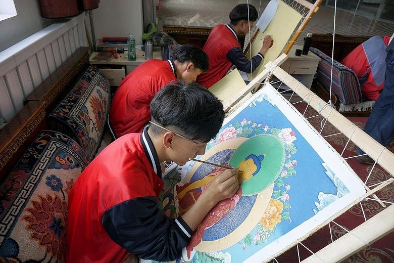 Second-year student Ciwang Nazha, 18, of Lhasa No.2 Secondary Vocational and Technical School engaging in Thangka (Tibetan Buddhist) painting alongside other students.