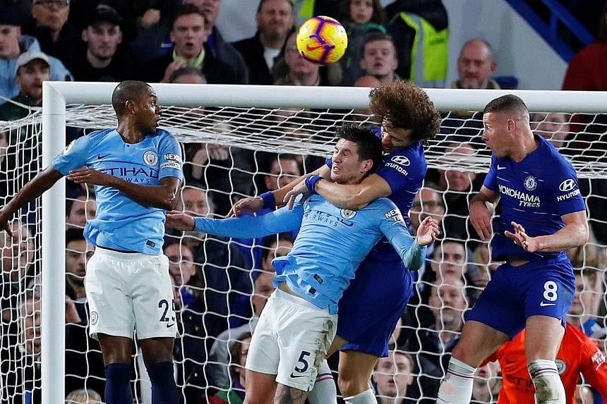 David Luiz, with his left arm wrapped around City defender John Stones, heading in Chelsea's second goal from a corner.