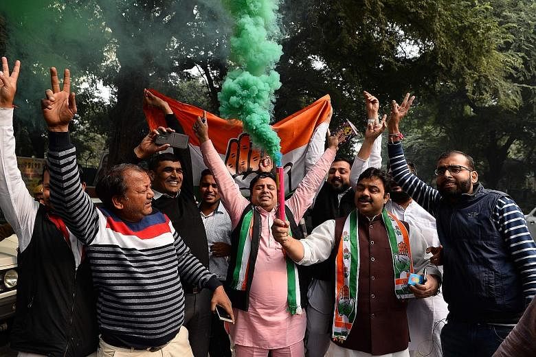 India's Congress party supporters celebrating outside the party headquarters in New Delhi yesterday.