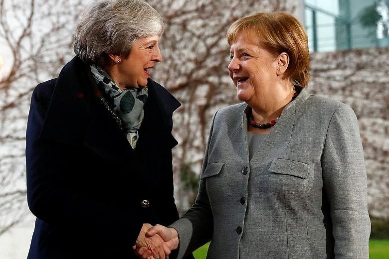 British Prime Minister Theresa May (left) being welcomed by German Chancellor Angela Merkel in Berlin yesterday. Mrs May has travelled to the European continent in a bid to shore up support to save her Brexit deal, which has come under attack from he