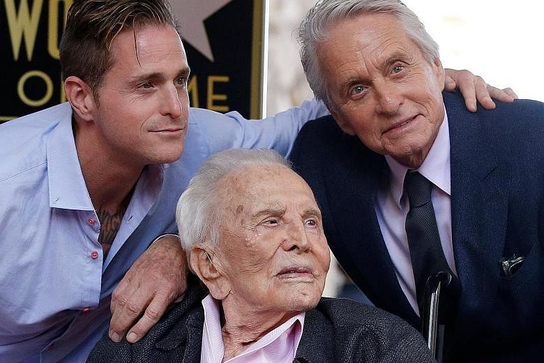 Veteran actor Kirk Douglas (centre) at the unveiling of the Hollywood Walk of Fame star of his son, Michael (right), last month. With them is Michael's son Cameron.