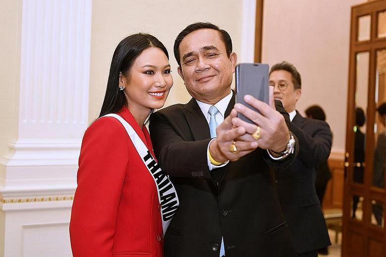 Thai Prime Minister Prayut Chan-o-cha taking a selfie with Thailand's Miss Universe 2018 contestant Sophida Kanchanarin after a meeting at Government House in Bangkok on Tuesday. Some politicians say having Mr Chan-o-cha return as premier would give 