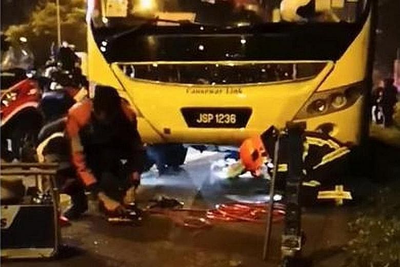 Rescue efforts under way at the scene of the accident on Wednesday night. The female pillion rider, who was pinned under the Causeway Link bus, died in hospital.