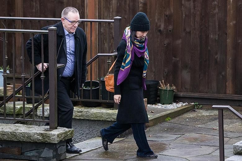 Huawei's chief financial officer Meng Wanzhou leaving her home under the supervision of security in the Canadian city of Vancouver on Wednesday. She faces an 11pm to 7am curfew while on bail.
