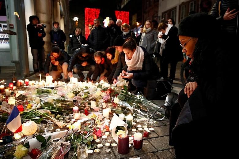 People lighting candles in tribute to the victims of the deadly shooting in Strasbourg, France, on Thursday.