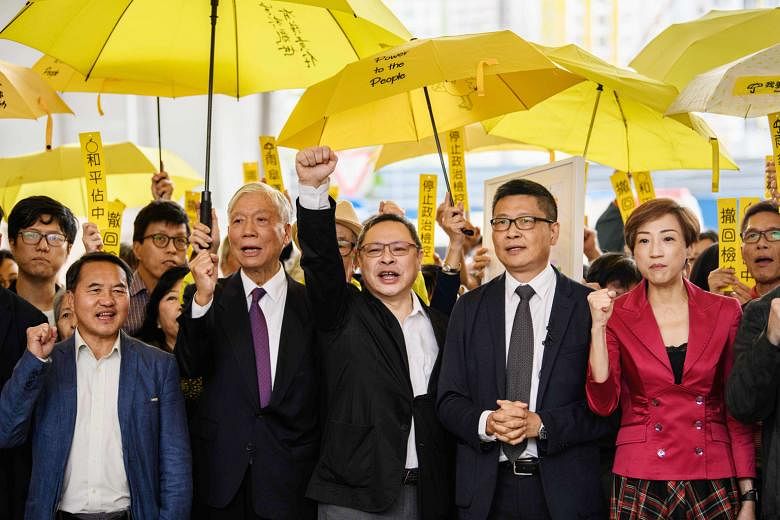 Pro-democracry activists, including (from second from left) Baptist minister Chu Yiu Ming, 74, law professor Benny Tai and sociology professor Chan Kin Man, 59, chanting before entering a Hong Kong court last month. Nine defendants face up to seven years 