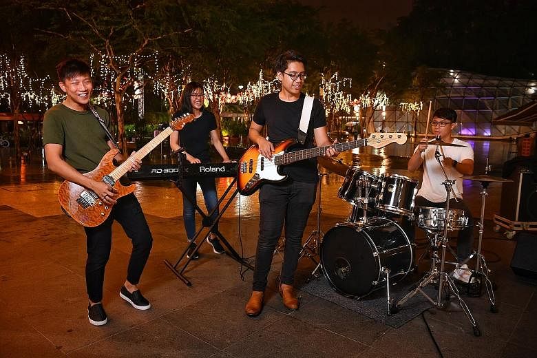 (From far right) 4th Dimension drummer Desmond Tan, 18, with bassist and singer Ahmad Irfan Ahmad Zaidi, pianist Lok Jia Yu and guitarist Joshua Tan, all 19, performing at the block party outside Plaza Singapura yesterday.