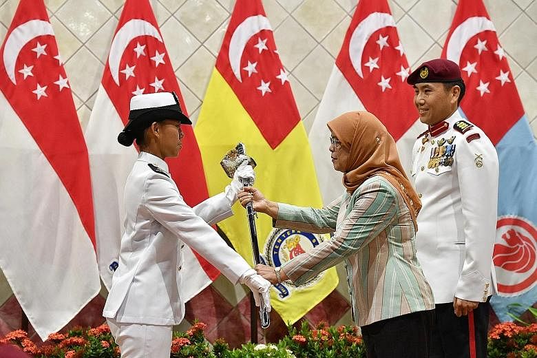 Left: Officer cadets braving the rain during the officer commissioning parade at Safti Military Institute yesterday. Right: Second-Lieutenant Audrey Tey Ee Teng, 19, receiving the sword of honour from President Halimah Yacob. The intake of 384 cadets