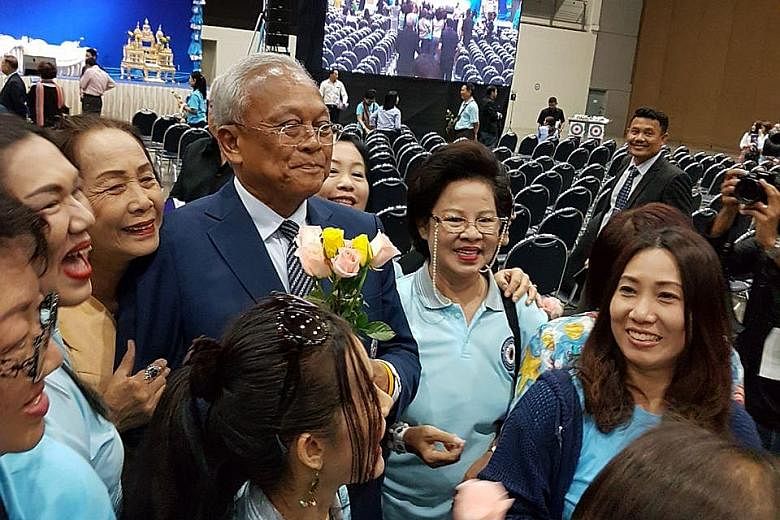 Supporters surrounding former deputy prime minister Suthep Thaugsuban at an intra-party voting centre yesterday. He promised not to rejoin politics after leading the 2014 street protests.