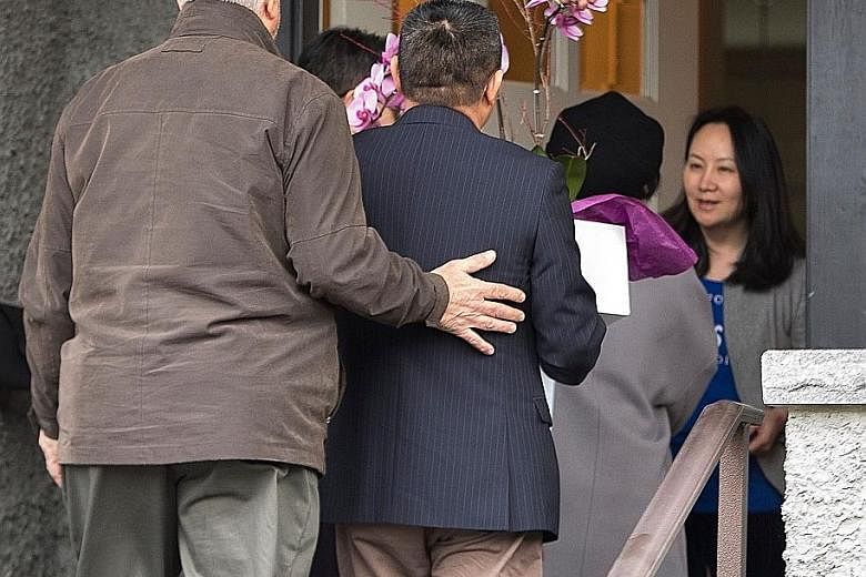 Ms Meng Wanzhou (right in picture), greeting people delivering flowers to her home in Vancouver last Wednesday after she was released on bail. She lives in Shenzhen, but also has two homes in Canada and a duplex in Hong Kong.