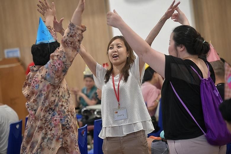 Ms Sherry Soon (centre), founder of Be Kind SG, and another volunteer (at right) engaging residents of a home the group visits in fun and games. Be Kind SG offers micro volunteering opportunities where people can pick and choose the activities they w