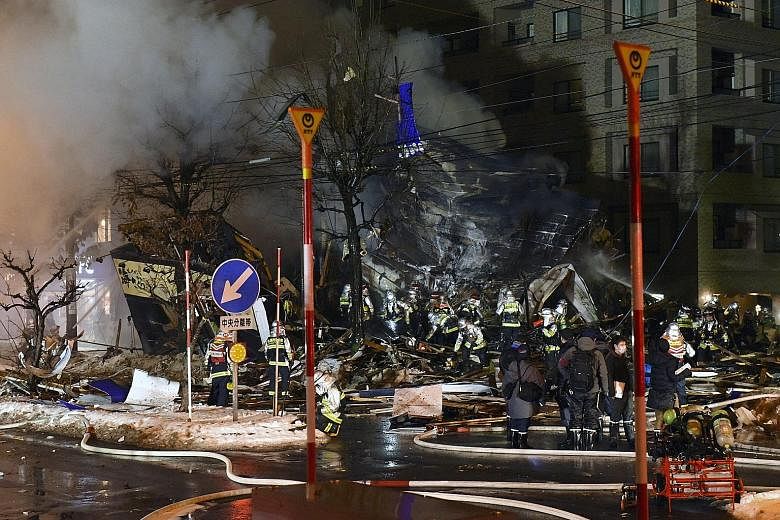 Firefighters putting out a blaze at the site of a restaurant that was razed by an explosion in Sapporo, northern Japan, yesterday. At least 42 people were injured in the blast at the two-storey Umi Sakura izakaya bar in Hiragishi district. One of the