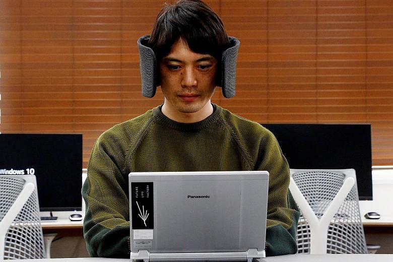 A designer at Panasonic wearing a prototype of "Wear Space", a headset that limits noise and peripheral vision.