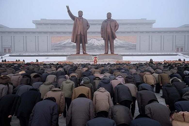 Pyongyang residents bowing before the statues of late North Korean leaders Kim Il Sung (far left) and Kim Jong Il during National Memorial Day on Mansu Hill in Pyongyang yesterday. North Korea marked the seventh anniversary of the death of Mr Kim Jon