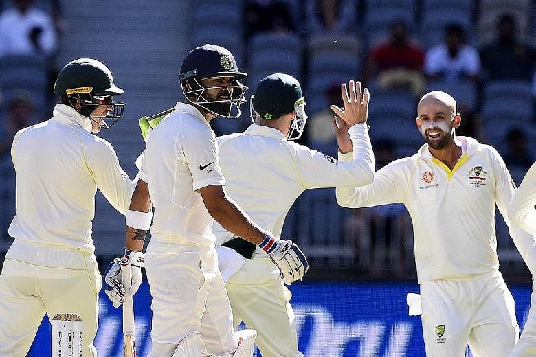 India captain Virat Kohli (left) is dismayed after being dismissed by Australian bowler Nathan Lyon for 17 runs on day four of the second Test match between Australia and India at Perth Stadium yesterday. Australia are poised for their first Test vic