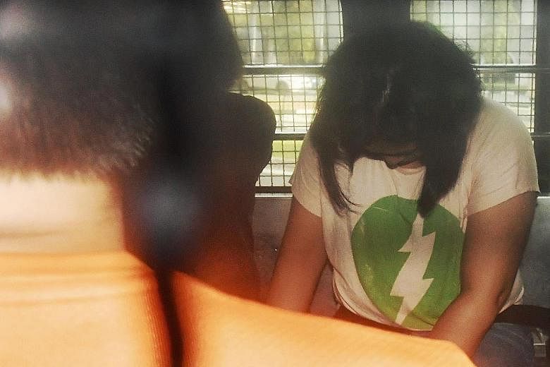One of the four shoplifters in a police van. She and three other Vietnamese stole more than 1,400 items from various Uniqlo stores.