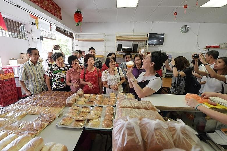 Participants taking in the strong aroma of freshly baked bread at Sweetlands Confectionery and Bakery yesterday in Kim Keat Lane, where they learn the process of making bread the old-fashioned way. The stretch of Sim Kwong Ho shophouses in Balestier 