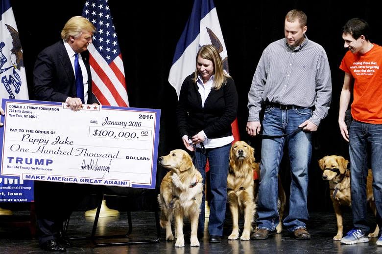 A file photo of then presidential candidate Donald Trump presenting a cheque from the Trump Foundation to the Puppy Jake Foundation in 2016.
