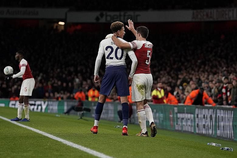 Above: Son Heung-min scoring past Arsenal goalkeeper Petr Cech to put Tottenham in the lead in their League Cup quarter-final at the Emirates Stadium. Left and below: Spurs' Dele Alli being led away by the Gunners' Sokratis Papastathopoulos after bei