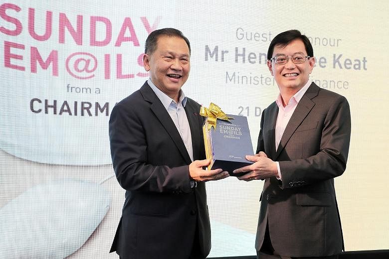 Mr Liew Mun Leong (left), chairman of Changi Airport Group and Surbana Jurong, presenting a box set of his books to Finance Minister Heng Swee Keat after the book launch at the National Library yesterday.