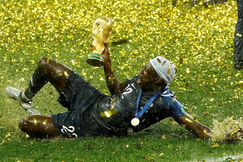 France defender Benjamin Mendy could not contain his joy in the rain as he lifts the World Cup trophy after Les Bleus beat Croatia 4-2 in the final on July 15.