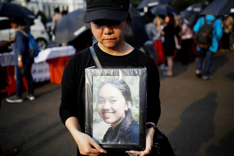 A woman with a photo of a relative, one of the 189 people killed in October's Lion Air plane crash in Indonesia. The final report on the crash is due in 10 months' time.