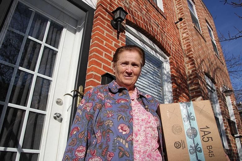 Baltimore resident Rosemarie Dumhart, 79, uses a decoy package, marked with an X, to discourage the so-called "porch pirates" operating in the Canton area of Baltimore, Maryland.