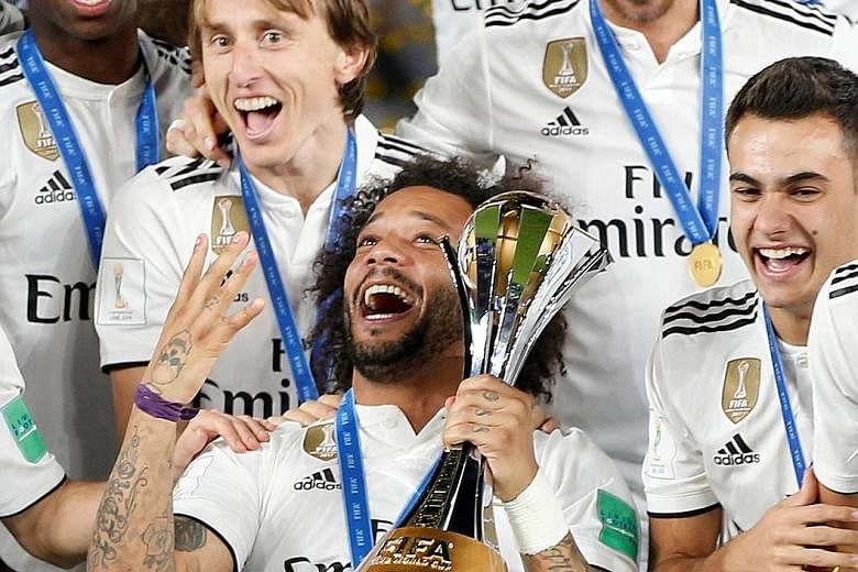 Real Madrid players celebrating after winning the Fifa Club World Cup for a record fourth time in Abu Dhabi on Saturday.