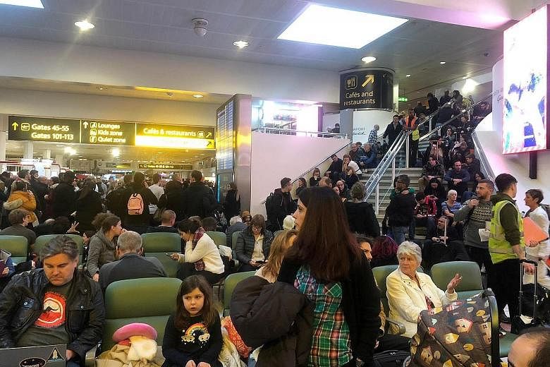 Stranded passengers at Gatwick Airport during the airport runway's closure last week over the disruption caused by drones. The chaos affected more than 140,000 passengers in Britain and reverberated around the world. A man and a woman (below) were in