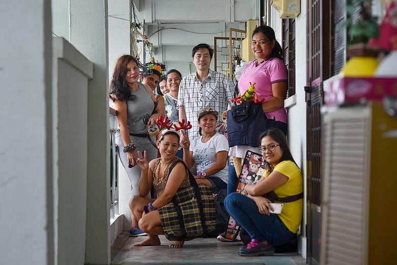 Mr Colin Lau, founder of Freegan in Singapore, with some of the maids who attended the giveaway party. To date, he has held 136 such events at his flat, where the maids are free to take any items he and some members of his group have found.