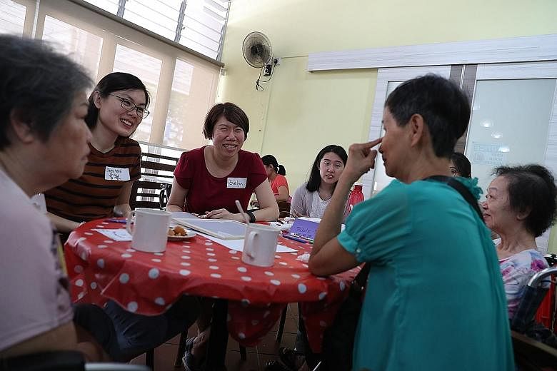 Volunteers singing Christmas carols and engaging participants at the Chit Chat Cafe session. The cafe is open one Saturday a month and orders are paid for with free vouchers issued to those who attend. Ms Evelyn Khoo (in red), who started Chit Chat C