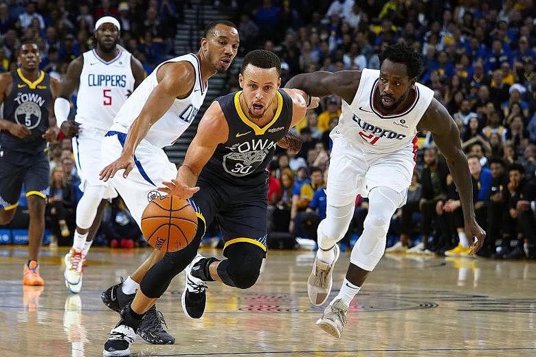 Golden State Warriors star Stephen Curry dribbling past Los Angeles Clippers guards Avery Bradley and Patrick Beverley (No. 21) on Sunday. Curry scored 42 points, including the game winner with half a second left, to help the Warriors overcome a hist