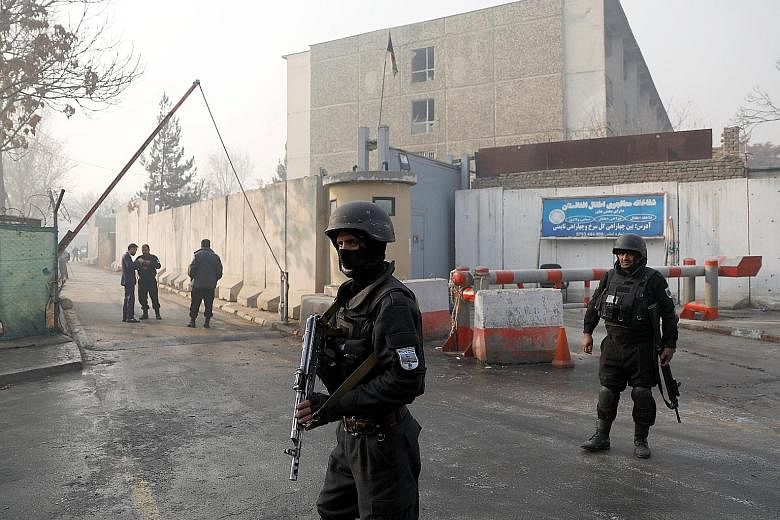 Afghan police officers standing guard outside the government compound in Kabul, after Monday's attack, the first major violent assault in the capital since last month, when a terrorist bomber killed more than 50 people in a hotel.