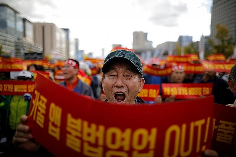 A taxi driver in South Korea protesting in October against a carpool service application to be launched by Kakao Corp later in the year. The banners read: "Stop carpool service application, it is illegal business." Such protests have made it hard for