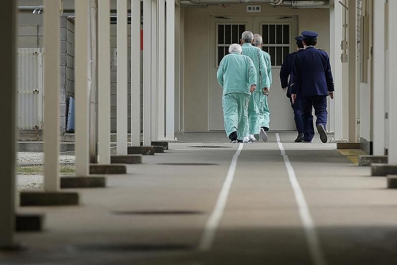 Prison guards escorting inmates along a marked pathway at Sasebo Prison in Nagasaki prefecture. The Justice Ministry's annual White Paper on crime noted that 19 per cent of elderly men and 34 per cent of elderly women reoffended within two years of b