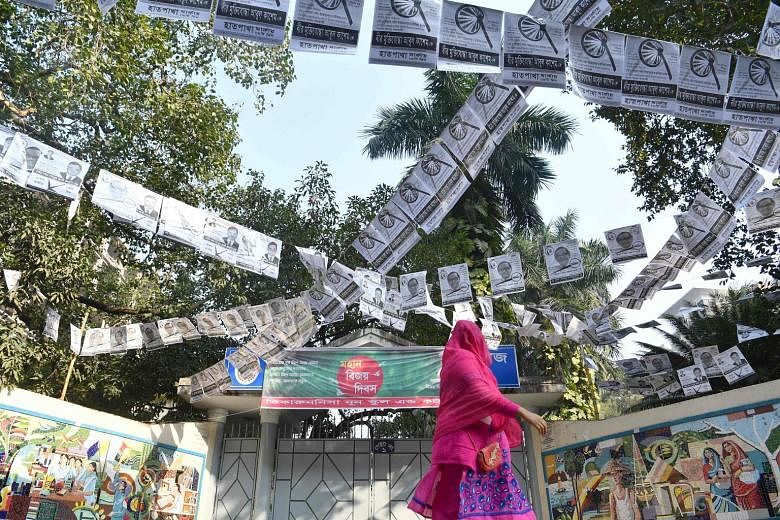 A street filled with election posters in Dhaka. The ruling Awami League is going up against a Bangladesh Nationalist Party-led opposition alliance in tomorrow's general election.