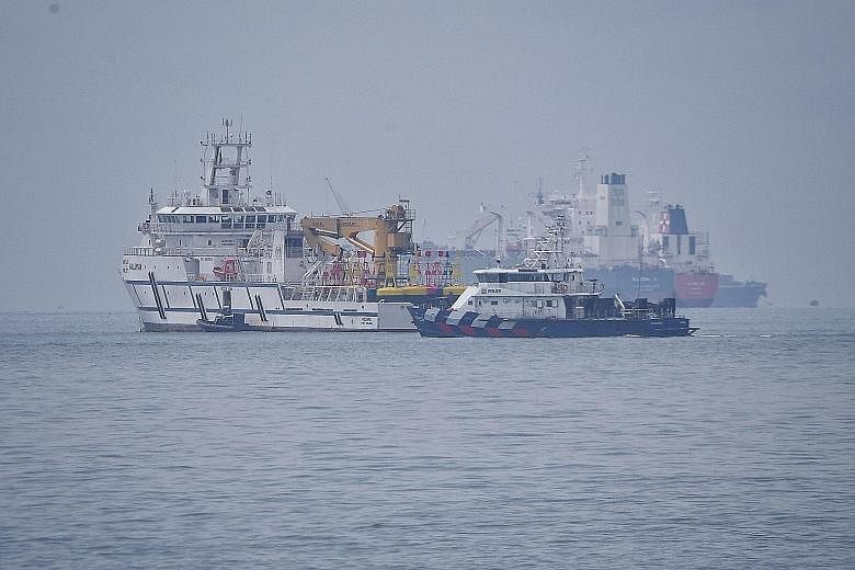 A Singapore Police Coast Guard vessel passing a Malaysian government vessel (left) in Singapore's territorial waters off Tuas on Dec 6. A territorial spat unfolded after Malaysia unilaterally extended the Johor Baru port limits.
