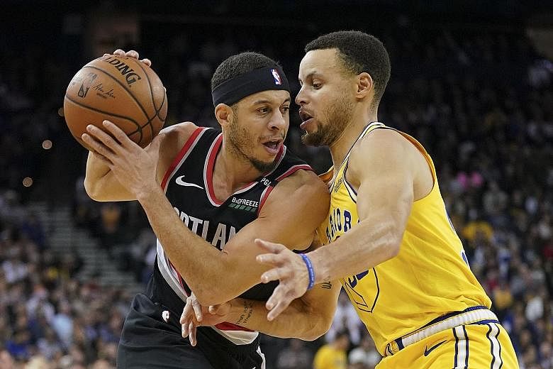 Portland Trail Blazers' Seth Curry being defended by his brother and Golden State Warriors guard Stephen Curry at the Oracle Arena on Thursday. Portland shocked the NBA champions with a 110-109 overtime win to hand the hosts their fifth home loss thi