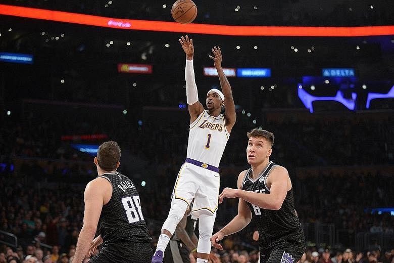 Lakers guard Kentavious Caldwell-Pope putting up a shot while Kings players Nemanja Bjelica (left) and Bogdan Bogdanovic look on during LA's 121-114 win on Sunday. Caldwell-Pope led the Lakers with 26 points.