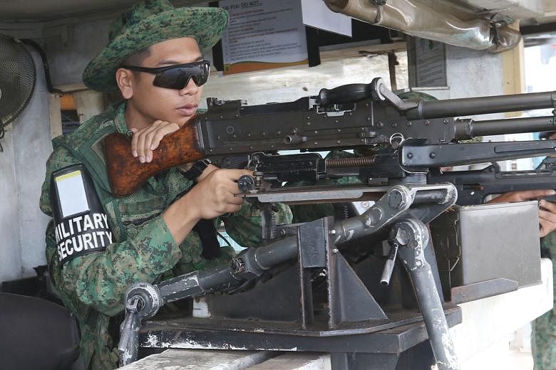Above: An army security trooper on watch with a GPMG, or general-purpose machine gun. 