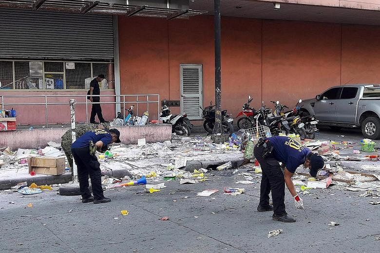 Police gathering evidence at the site of Monday's blast outside a shopping mall in Cotabato city, southern Philippines.