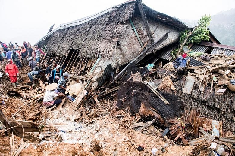 Rescue workers searching for victims yesterday near a collapsed house following landslides in Sukabumi regency in Indonesia's West Java province. Heavy rain in West Java and parts of the Philippines caused landslides and heavy flooding in the new yea